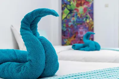 a blue dinosaur toy sitting on a bed at Koukaki Olympiou Apartment in Athens