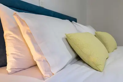 a pile of pillows sitting on top of a bed at Koukaki Olympiou Apartment in Athens