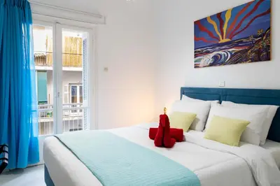 a red teddy bear sitting on top of a bed at Koukaki Olympiou Apartment in Athens