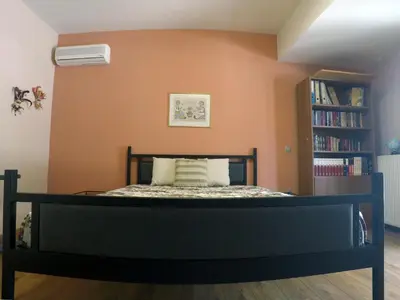 a bedroom with a bed with an orange wall at Luxury Villa with Private Pool in Keratea