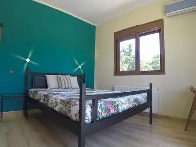 a bedroom with a bed with a green wall at Luxury Villa with Private Pool in Keratea