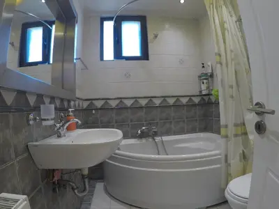 a bathroom with a tub and a sink and a toilet at Luxury Villa with Private Pool in Keratea