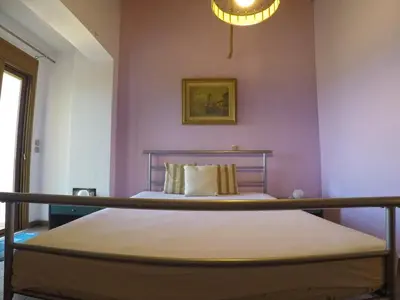 a bedroom with a bed with purple walls and a chandelier at Luxury Villa with Private Pool in Keratea