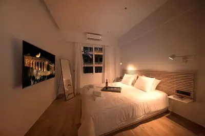 a bedroom with a large white bed and a window at Downtown Syntagma apartment 1 in Athens