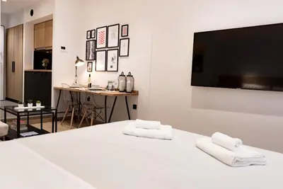 a white room with a bed with two white towels at Downtown Syntagma apartment 1 in Athens