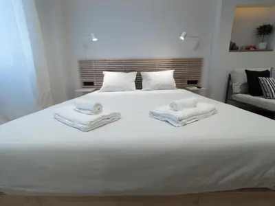 a bedroom with a white bed with towels on it at Downtown Syntagma apartment 1 in Athens