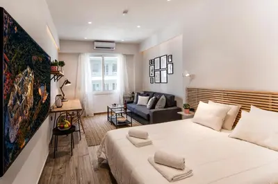 a bedroom with a large white bed and a couch at Downtown Syntagma apartment 3 in Athens