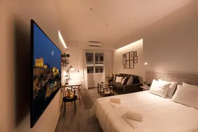 a bedroom with a large bed and a living room at Downtown Syntagma apartment 3 in Athens