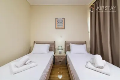 two twin beds in a room with a window at Thresh Apartments Airport by Airstay in Spáta