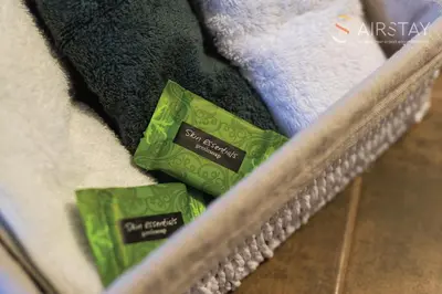 two packs of green and black towels on a couch at Thresh Apartments Airport by Airstay in Spáta