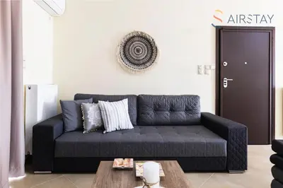 a living room with a couch and a coffee table at Thresh Apartments Airport by Airstay in Spáta