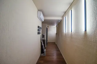 a hallway with white walls and wooden floors and windows at Still Athens in Athens