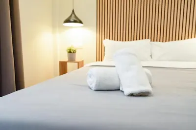 a bedroom with a white bed with towels on it at Still Athens in Athens