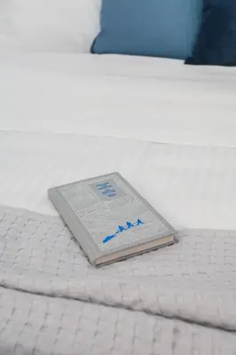 a book sitting on top of a bed at Bright 2BD Apartment in Psychiko by UPSTREET in Athens