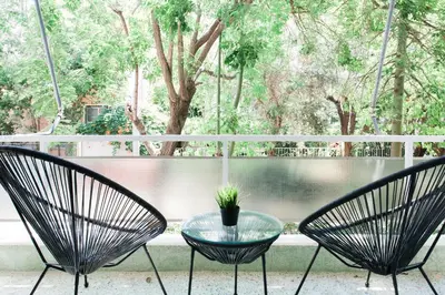 two chairs and a glass table in front of a window at Bright 2BD Apartment in Psychiko by UPSTREET in Athens