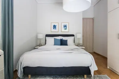 a bedroom with a large bed with blue pillows at Bright 2BD Apartment in Psychiko by UPSTREET in Athens
