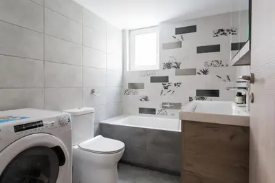 a bathroom with a toilet and a sink and a washing machine at Bright 2BD Apartment in Psychiko by UPSTREET in Athens