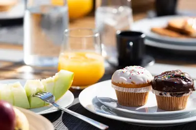 two cupcakes and apples on plates on a table at Athens View Loft 07 & 08 in Athens
