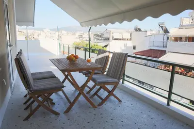 a table and chairs on a balcony with a view at ivannas penthouse in Athens