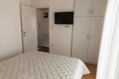 a bedroom with a bed and a flat screen tv at ivannas penthouse in Athens