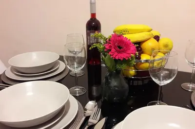 a table with a bottle of wine and a vase with a flower at Anna's Relaxing Dreamhouse in Athens