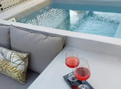 two glasses of red wine sitting on a couch at *** Boutique Syntagma apartment w/ plunge pool *** in Athens