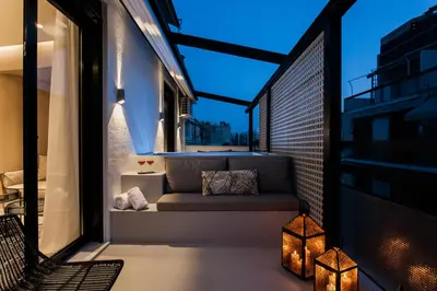 a balcony with a couch and two lights at *** Boutique Syntagma apartment w/ plunge pool *** in Athens