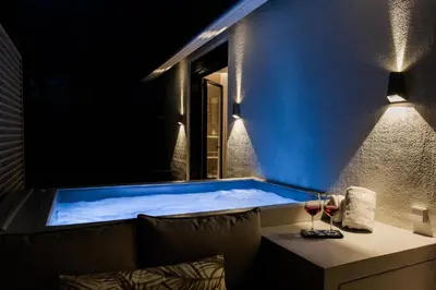 a jacuzzi tub with a window and two glasses of wine at *** Boutique Syntagma apartment w/ plunge pool *** in Athens