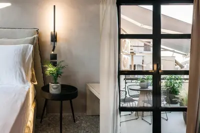 a bedroom with a bed and a view of a balcony at *** Boutique Syntagma apartment w/ plunge pool *** in Athens