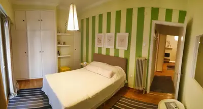 a bedroom with a bed and green and white stripes at Alexandra's path in Athens