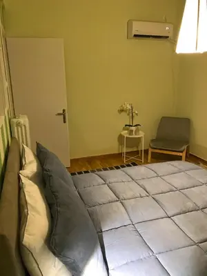 a bedroom with a large bed and a chair at Alexandra's path in Athens