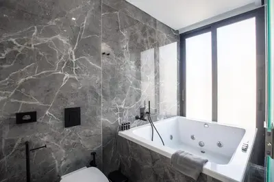a bathroom with a bath tub and a toilet at The Duke Boutique Suites in Athens