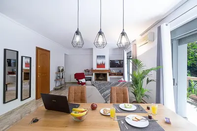 a kitchen and living room with a table and a laptop at L9 Athens in Athens