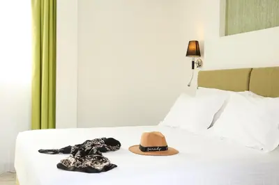 a hat and a dress on a bed at Athens Starlight Hotel in Athens