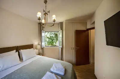 a bedroom with a bed and a tv and a window at 2 bedroom flat next to Acropolis in Athens