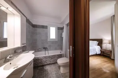 a bathroom with a sink and a toilet and a bed at 2 bedroom flat next to Acropolis in Athens