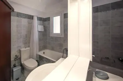 a bathroom with a white toilet and a sink at 2 bedroom flat next to Acropolis in Athens