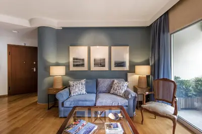 a living room with a blue couch and a table at 2 bedroom flat next to Acropolis in Athens