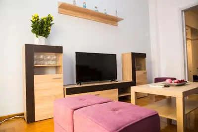 a living room with a tv and a purple stool at Acropolis,Historic center Apartment-update in Athens