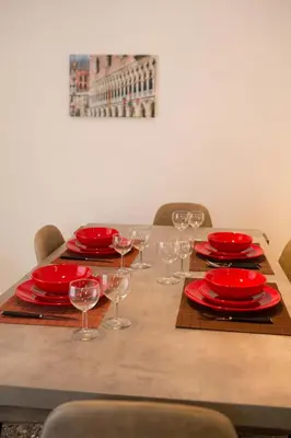 a wooden table with red plates and wine glasses at Acropolis,Historic center Apartment-update in Athens