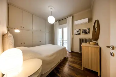 a bedroom with a bed and a table and a mirror at Brand new Modern Apartment with satellite TV in Athens