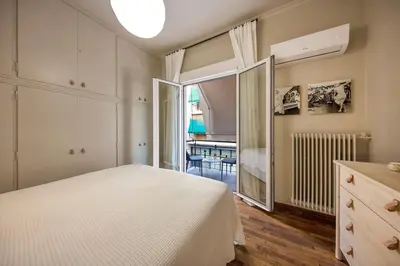 a bedroom with a large white bed and a window at Brand new Modern Apartment with satellite TV in Athens