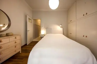 a bedroom with a large white bed and a mirror at Brand new Modern Apartment with satellite TV in Athens