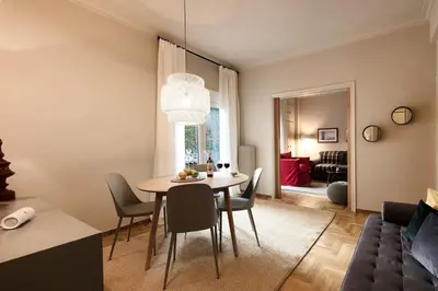 a dining room and living room with a table and chairs at Brand new Modern Apartment with satellite TV in Athens