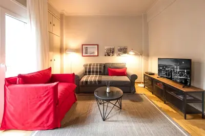 a living room with a red couch and a television at Brand new Modern Apartment with satellite TV in Athens