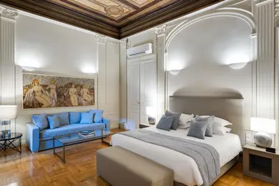 a bedroom with a king sized bed and a blue couch at 33SolonosSuites in Athens