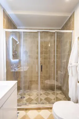 a bathroom with a shower with a toilet and a sink at 33SolonosSuites in Athens