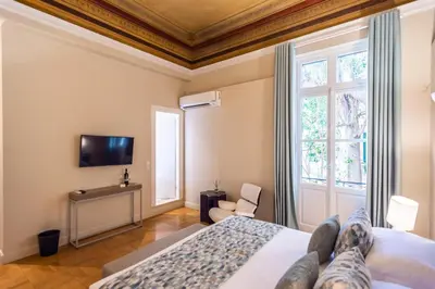a bedroom with a bed and a tv on the wall at 33SolonosSuites in Athens