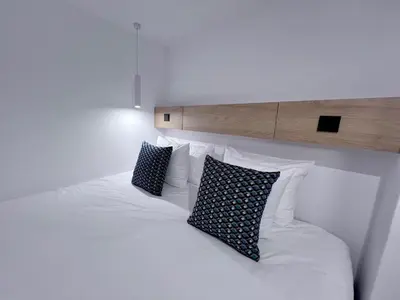 a bedroom with a white bed with two pillows at PINACOTA SUITES ATHENS in Athens