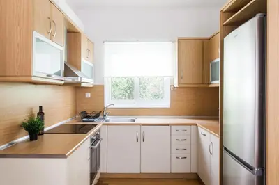 a kitchen with white cabinets and a window at Delightful 1BD Apartment in Plaka by UPSTREET in Athens